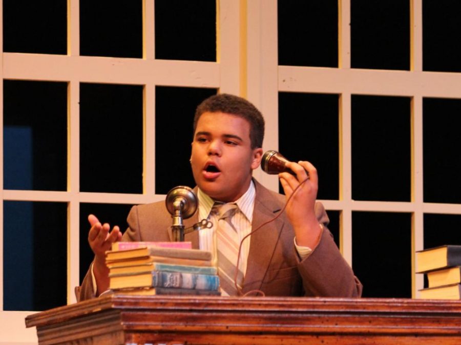 Gabriel Watkins-Mocumbi, playing Daddy Warbucks, talks through the phone to the president in the school musical, "Annie"