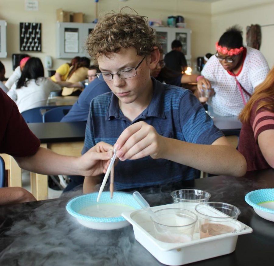 Jonas Ferguson pours melted ice cream into nitrogen to create Dip n Dots during science club.