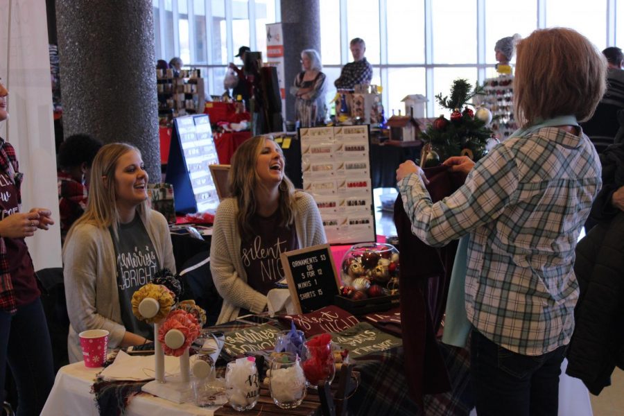 Venders chat with shoppers.  The vendors sold a wide variety of holiday items including t-shirts, ornaments, wine glasses, and more (Kenny Miller)