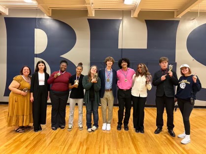 Battle Speech and Debate team pose for photo with their medals and awards