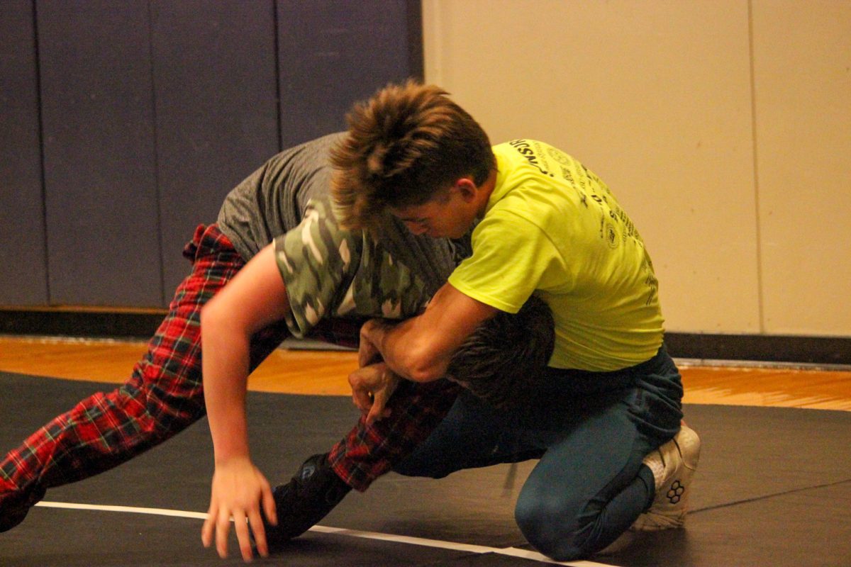 Ray Dennison (12) puts Shawn McGrail (10) in a cradle during practice